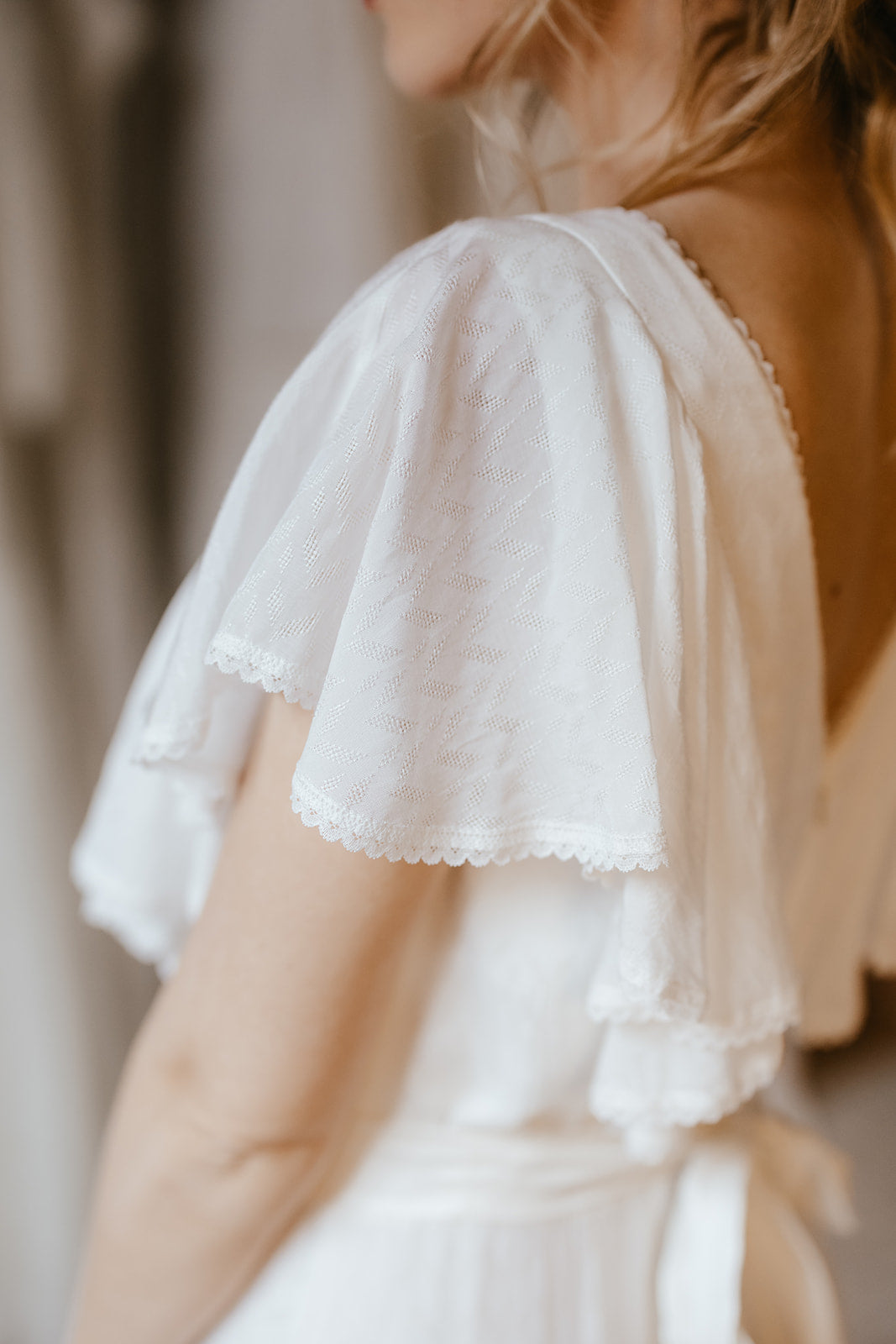 Bride wearing a modern wedding dress with a flutter sleeve.