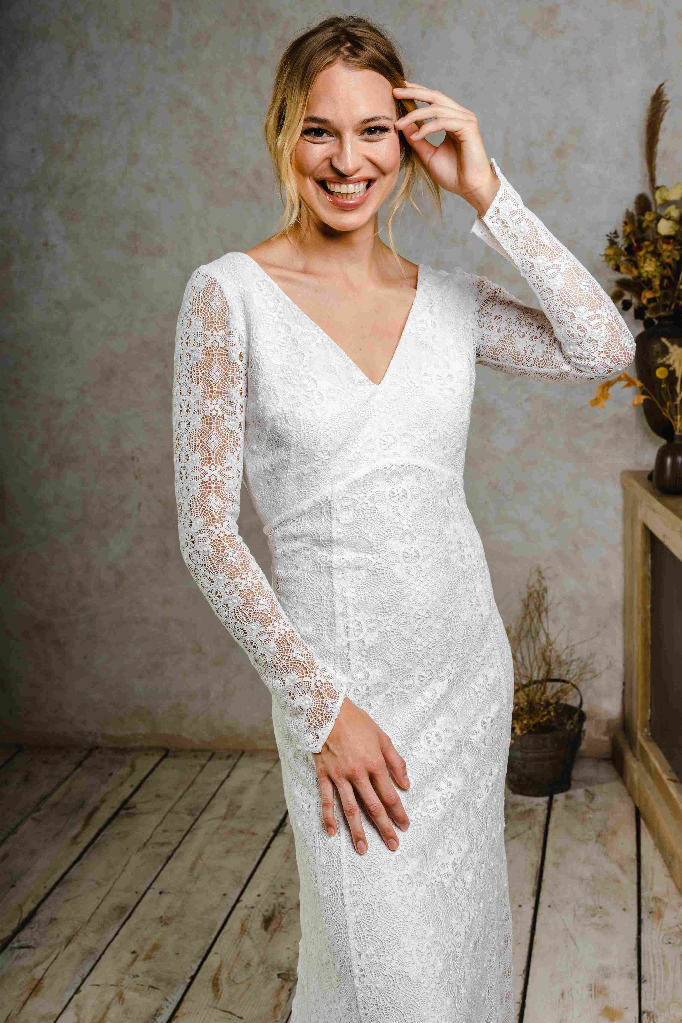 model wearing a modern bohemian lace wedding dress with sleeves