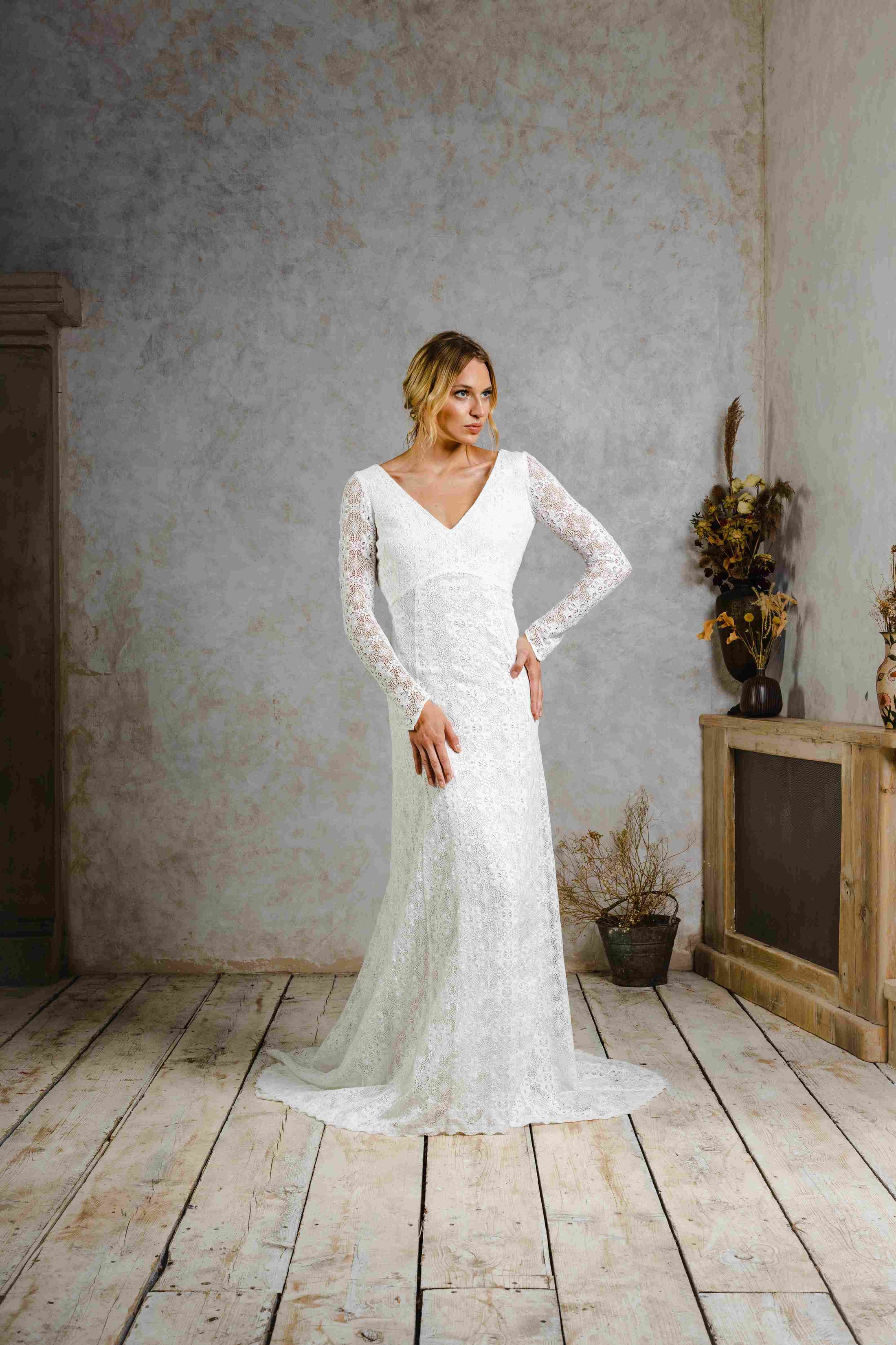 model wearing a modern bohemian lace wedding dress with sleeves