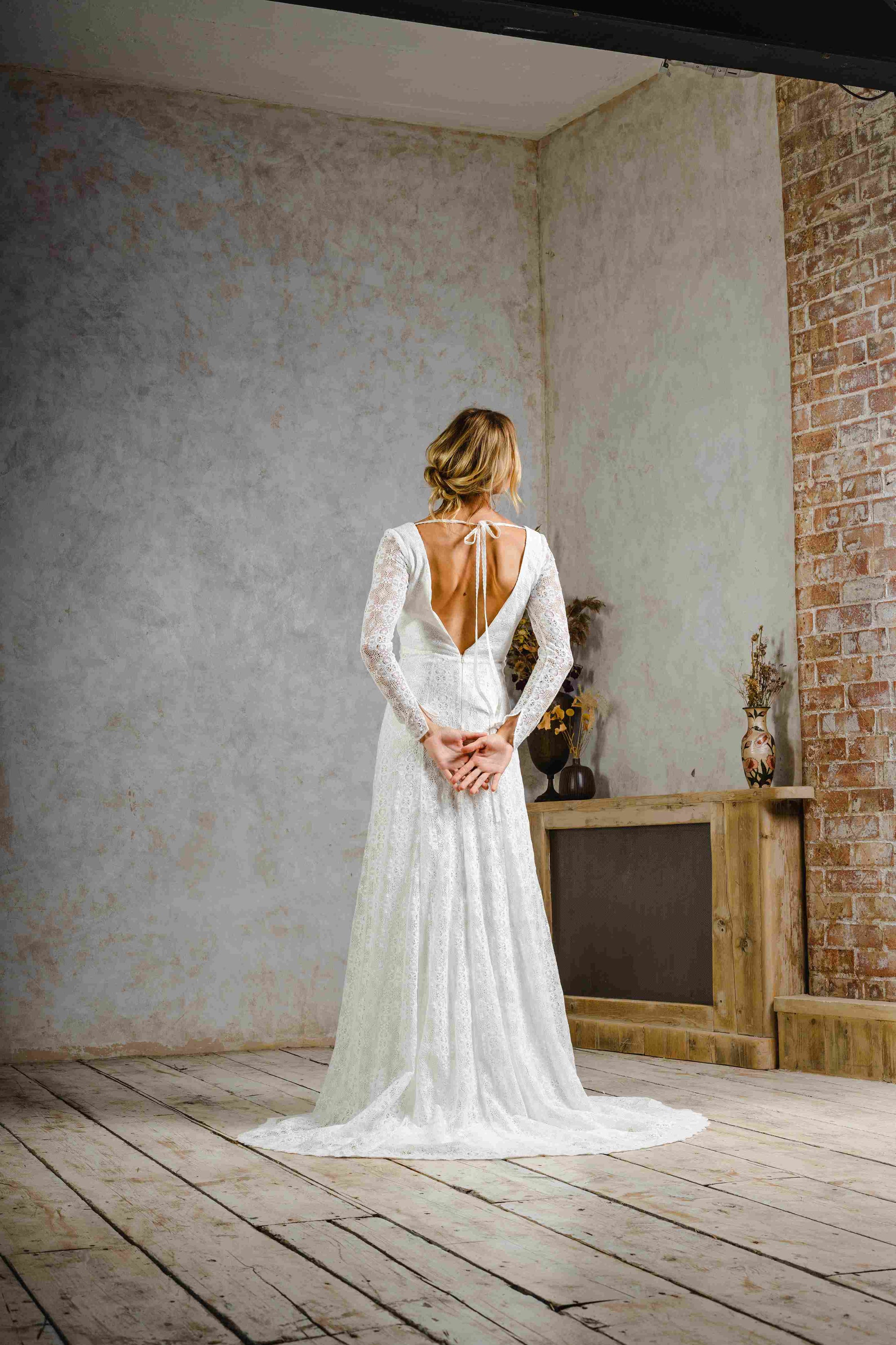 model wearing a modern bohemian lace wedding dress with sleeves