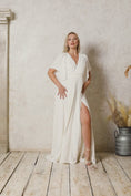 Load and play video in Gallery viewer, model wearing a modern wedding dress with sleeves and a skirt slit