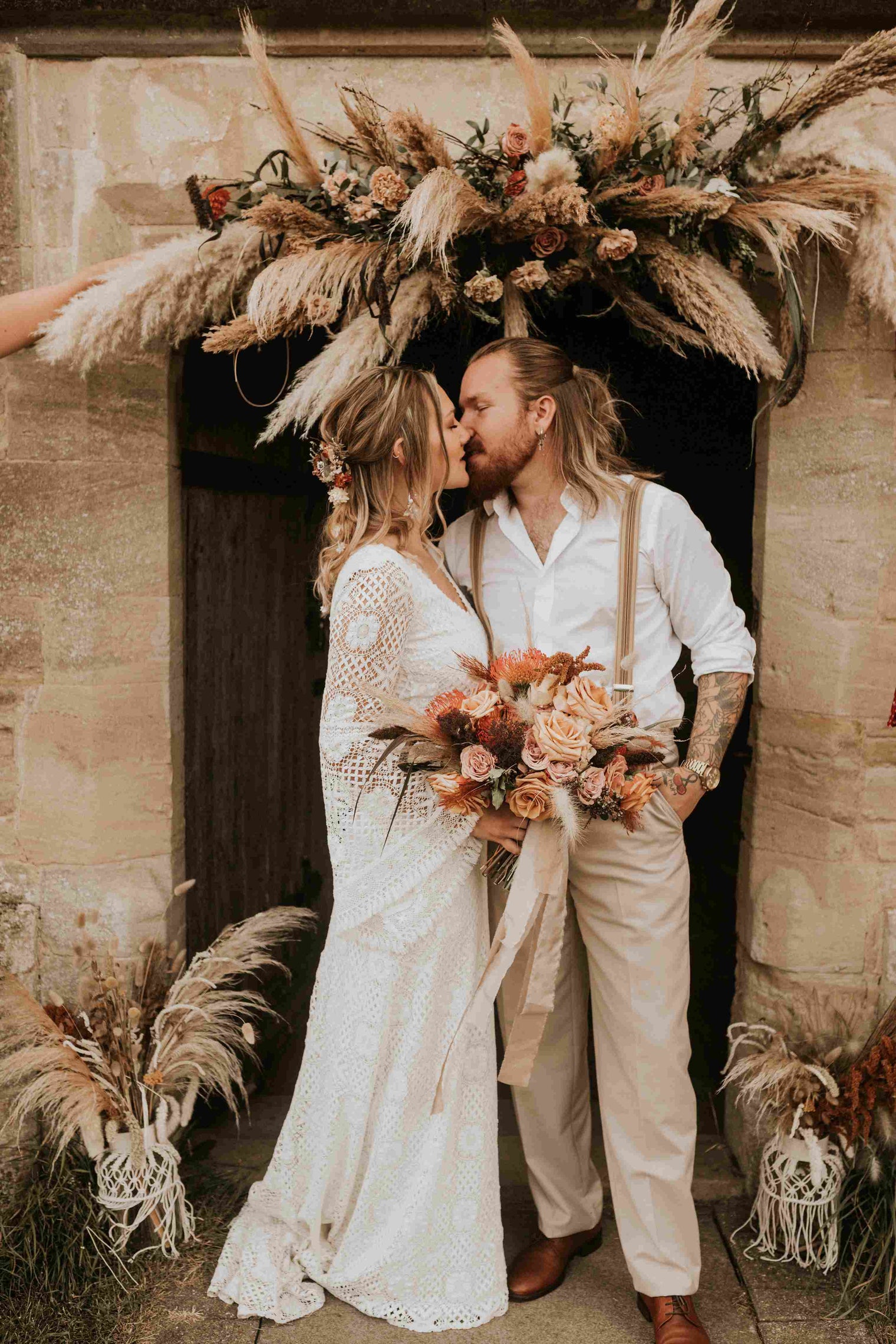 bohemian bride and groom bride wearing a lace wedding dress with bell sleeves