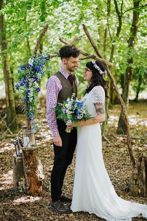 bride and groom standing in a forest at their woodland wedding