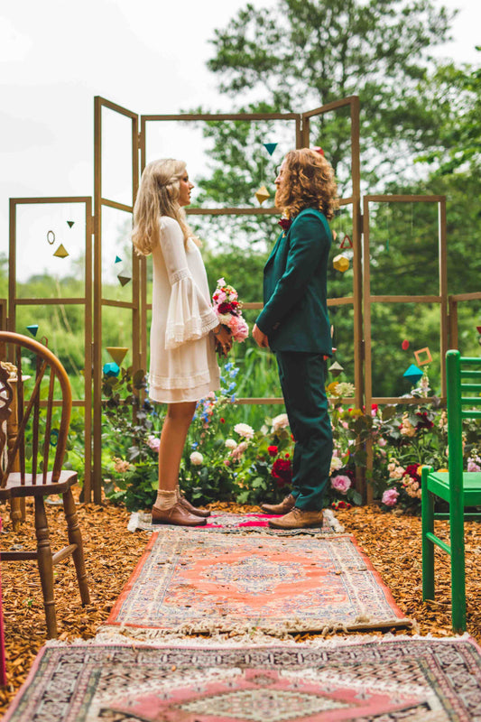 Bride and groom standing and holding hands at their Wes Anderson inspired wedding