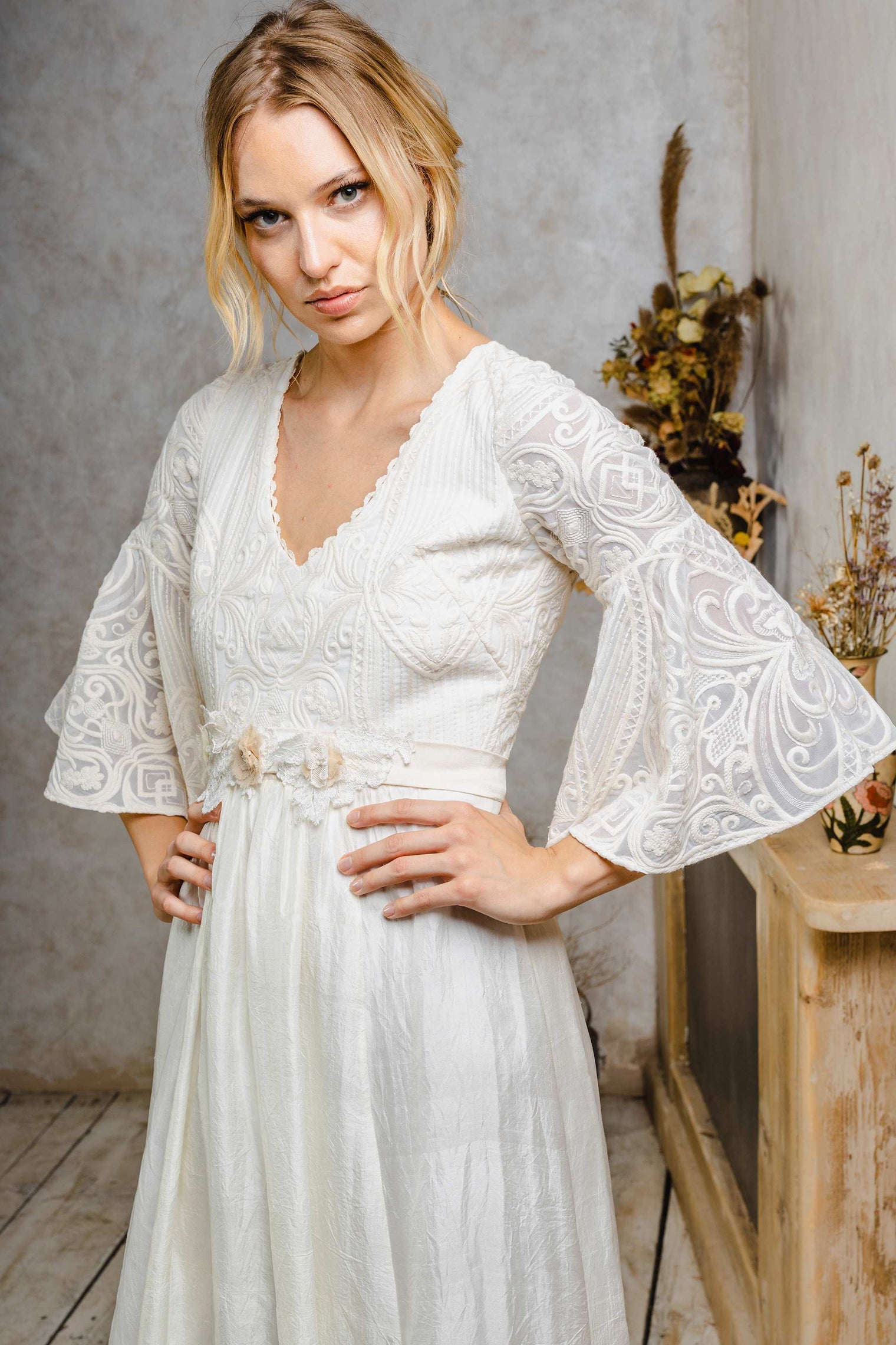 Woman wearing a boho wedding dress with bell sleeves.