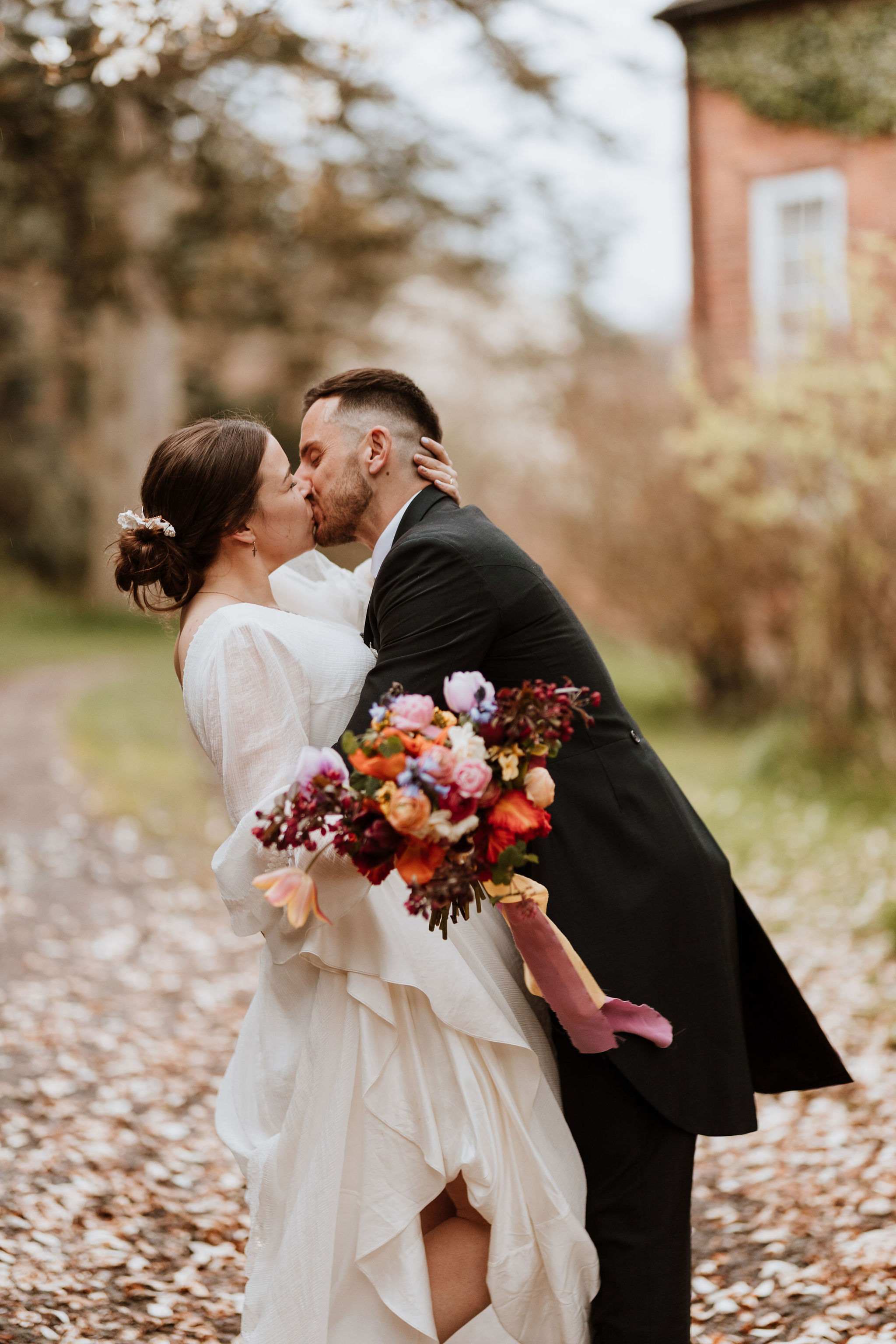 Bride and groom kissing outside.