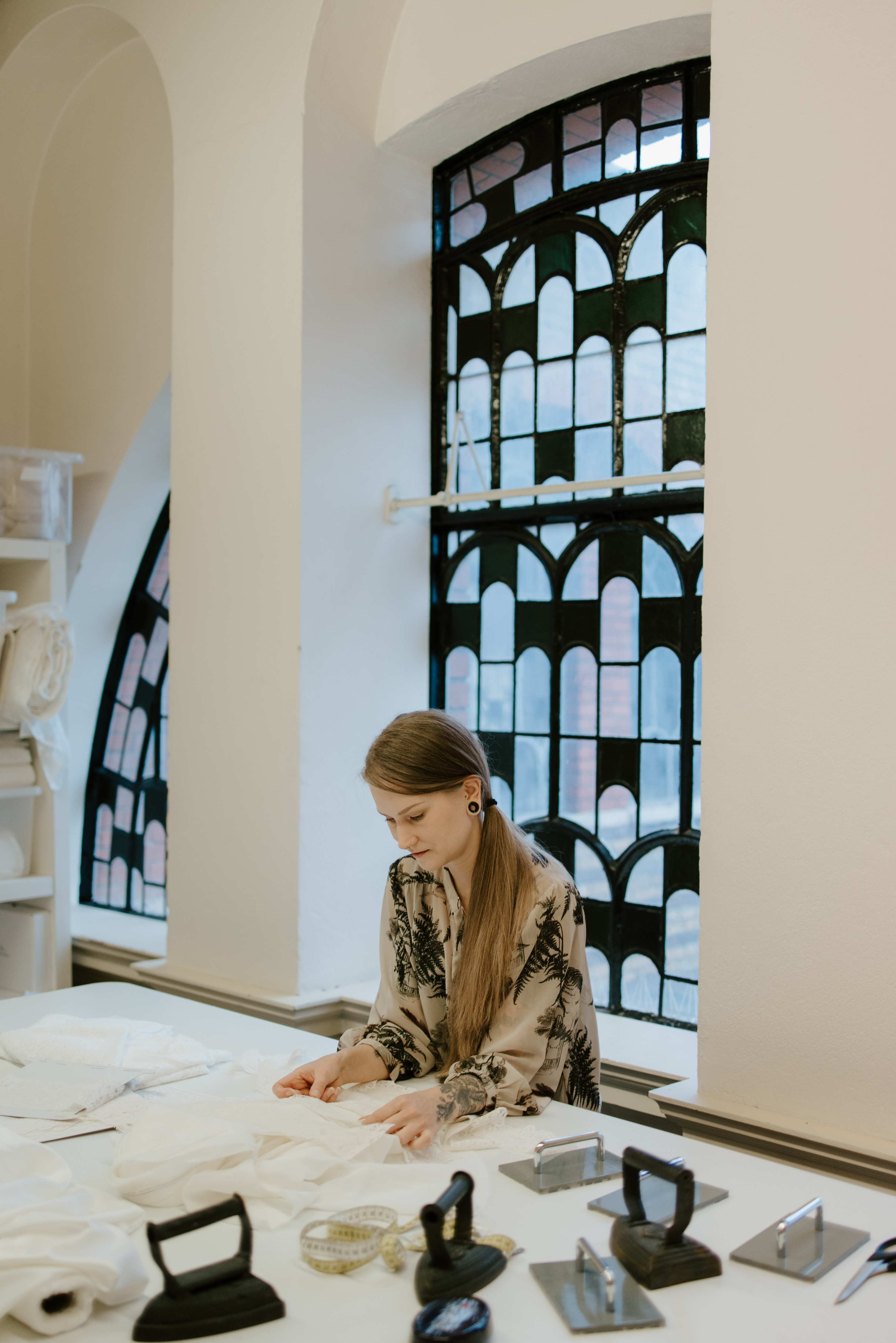 Dressmaker at her cutting table choosing materials.