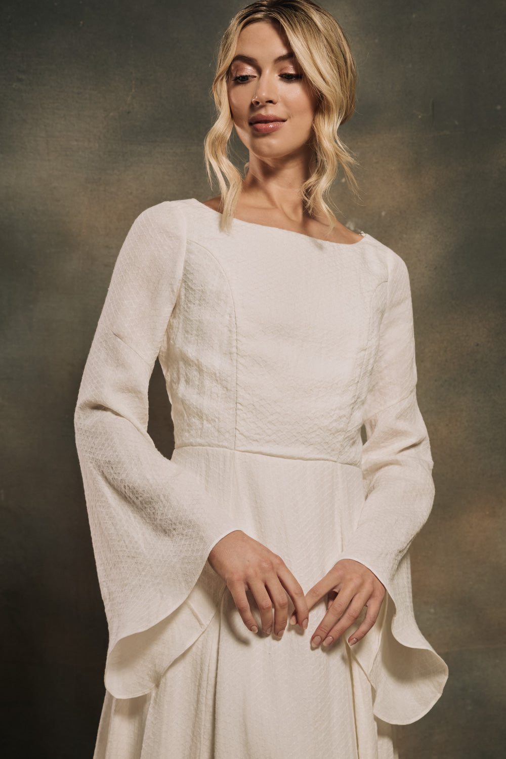 model wearing a linen wedding dress with flared sleeves