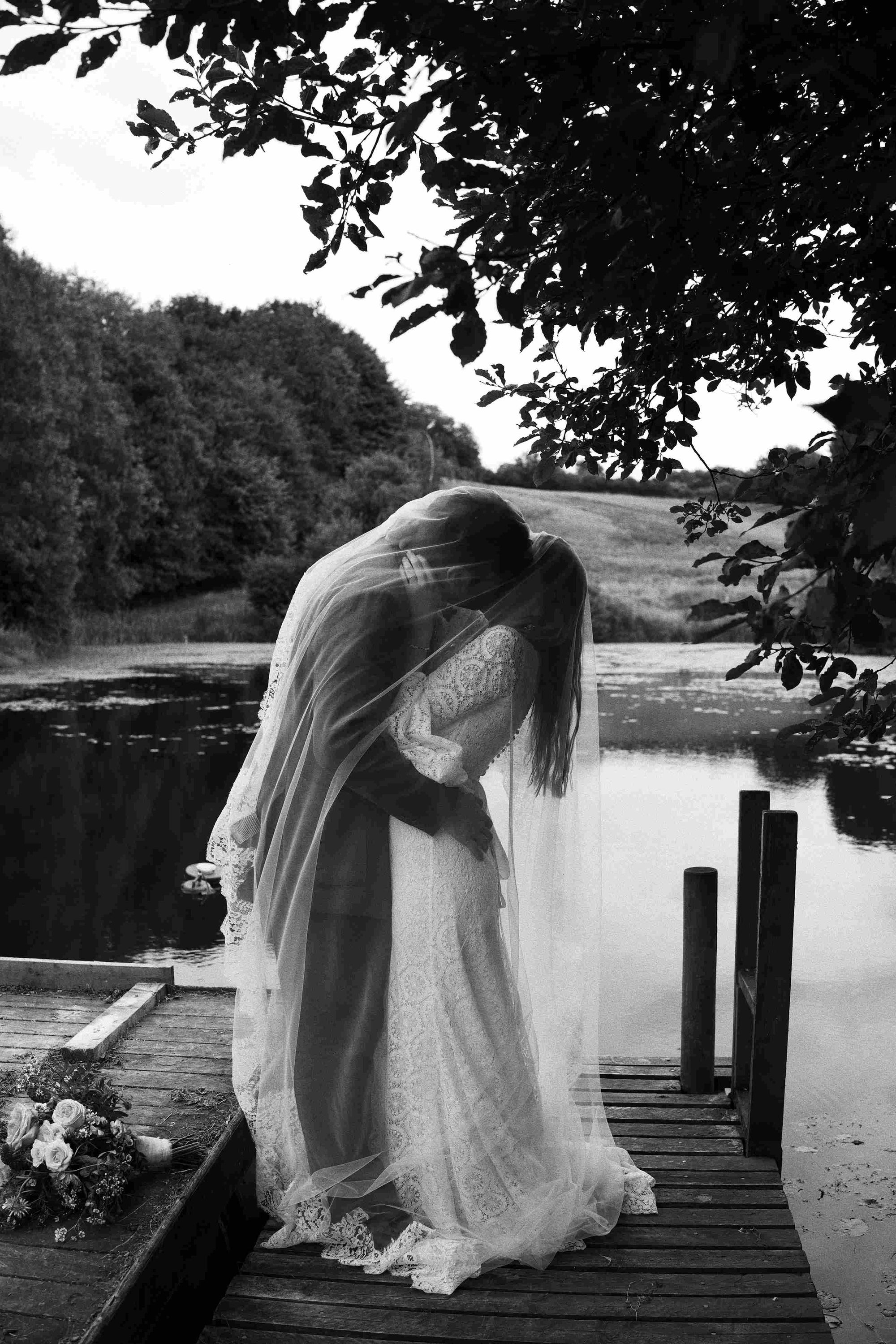 Bride and groom kissing on a pier