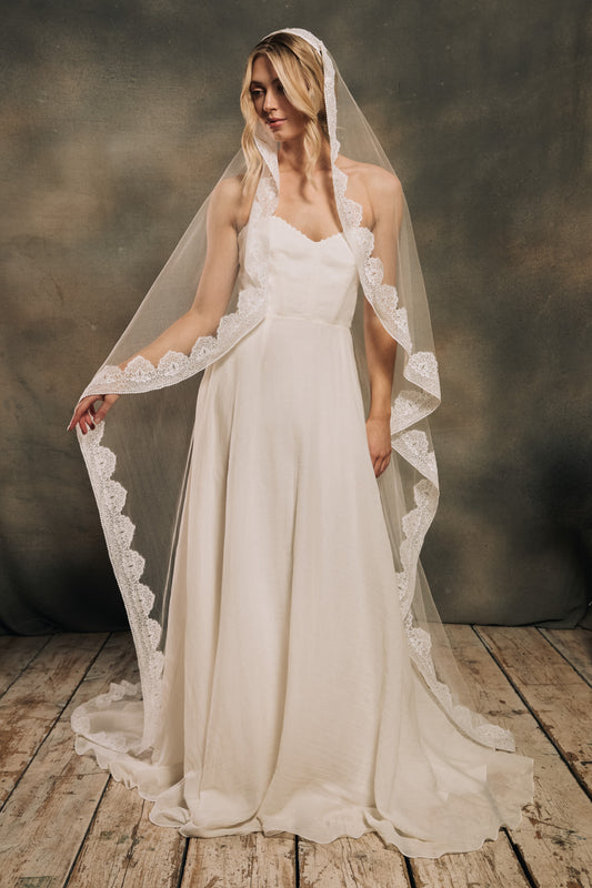 Model wearing a mantilla veil and a modern strapless wedding dress.