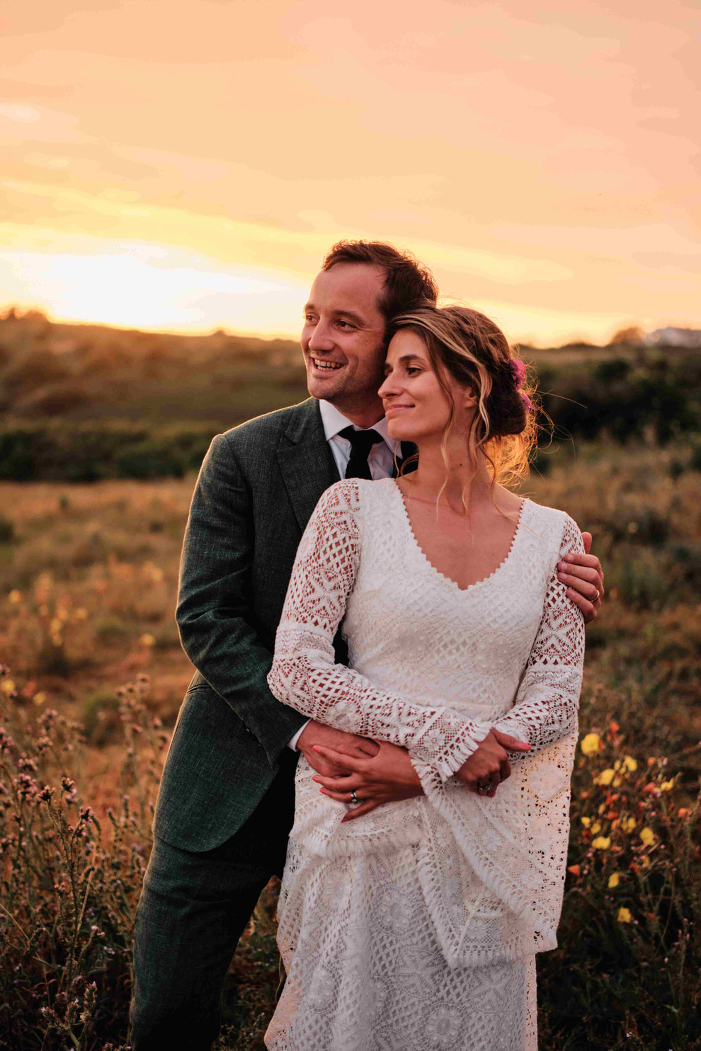 bride and groom embracing in sunset