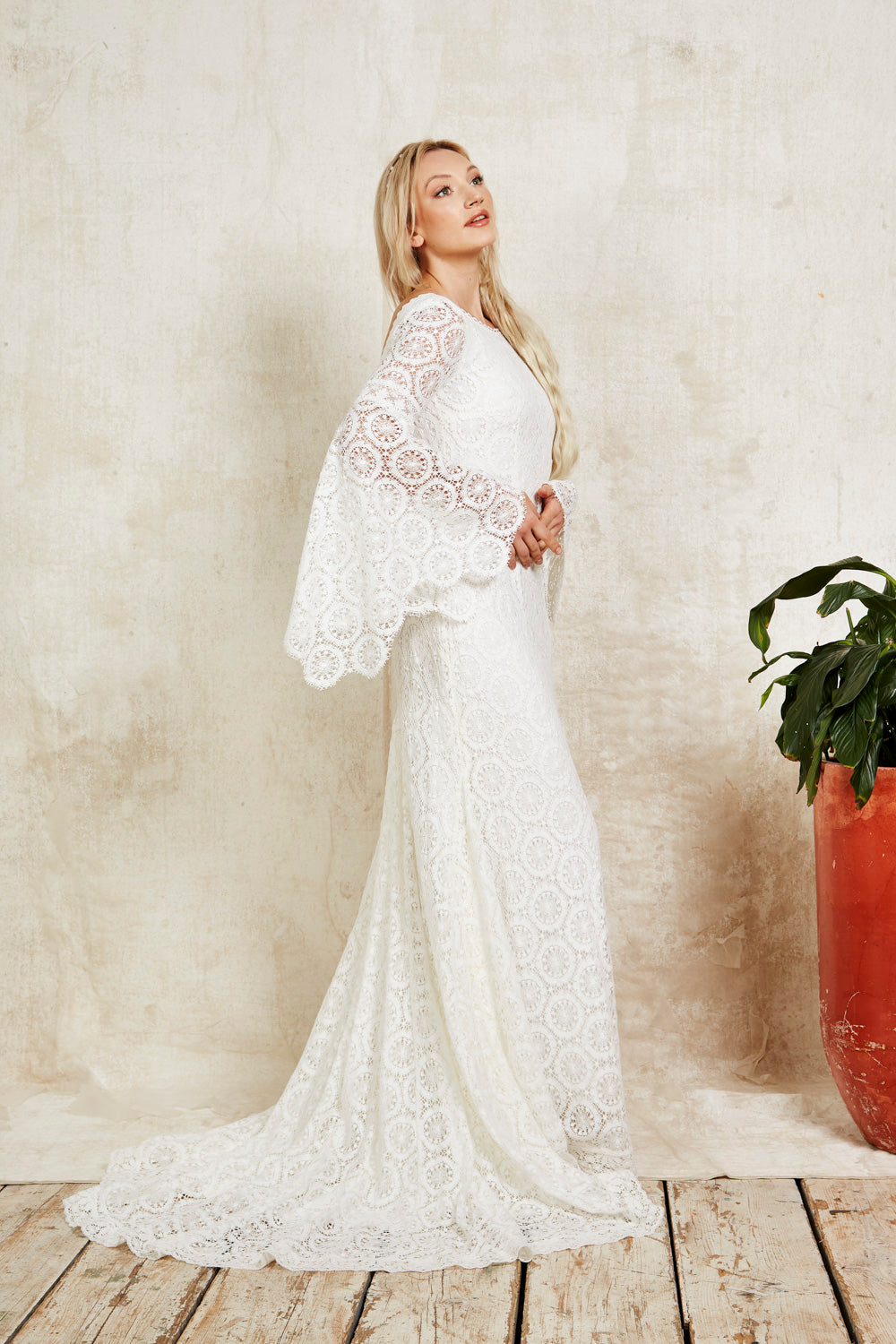 model wearing bohemian lace wedding dress with bell sleeves