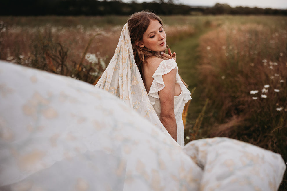 boho bride wearing a veil in a flower meadow