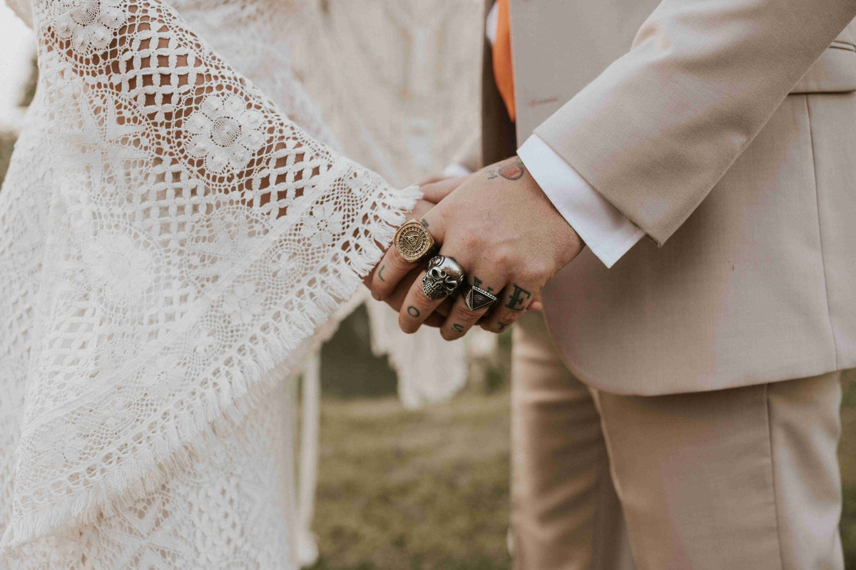 bohemian bride and groom holding hands