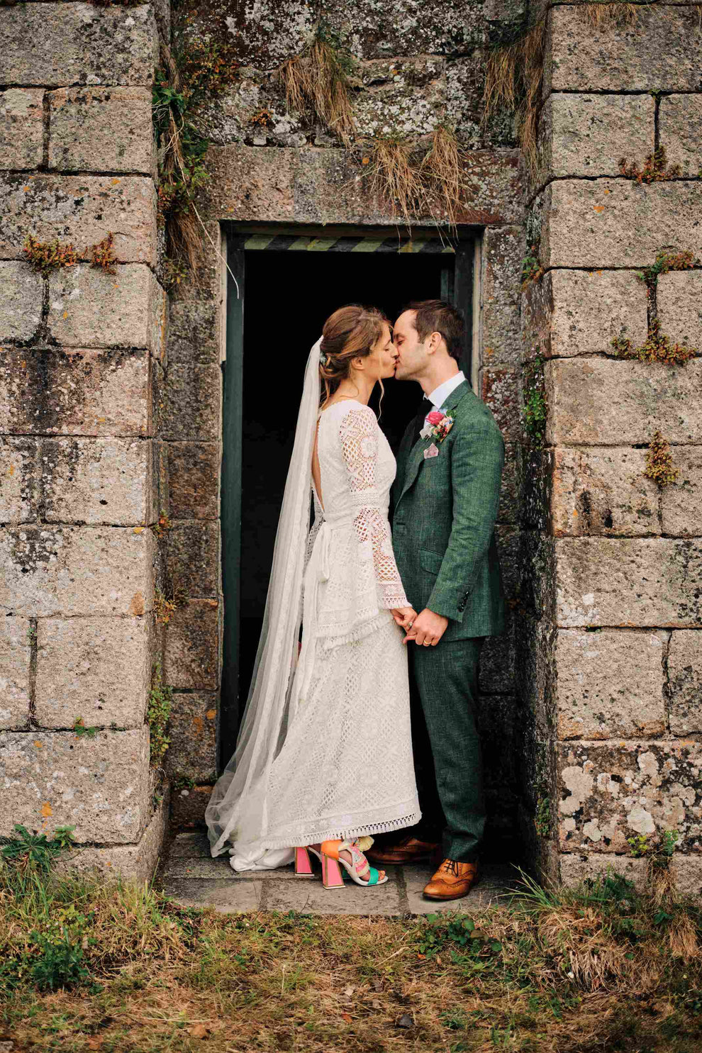 bride and groom kissing and holding hands