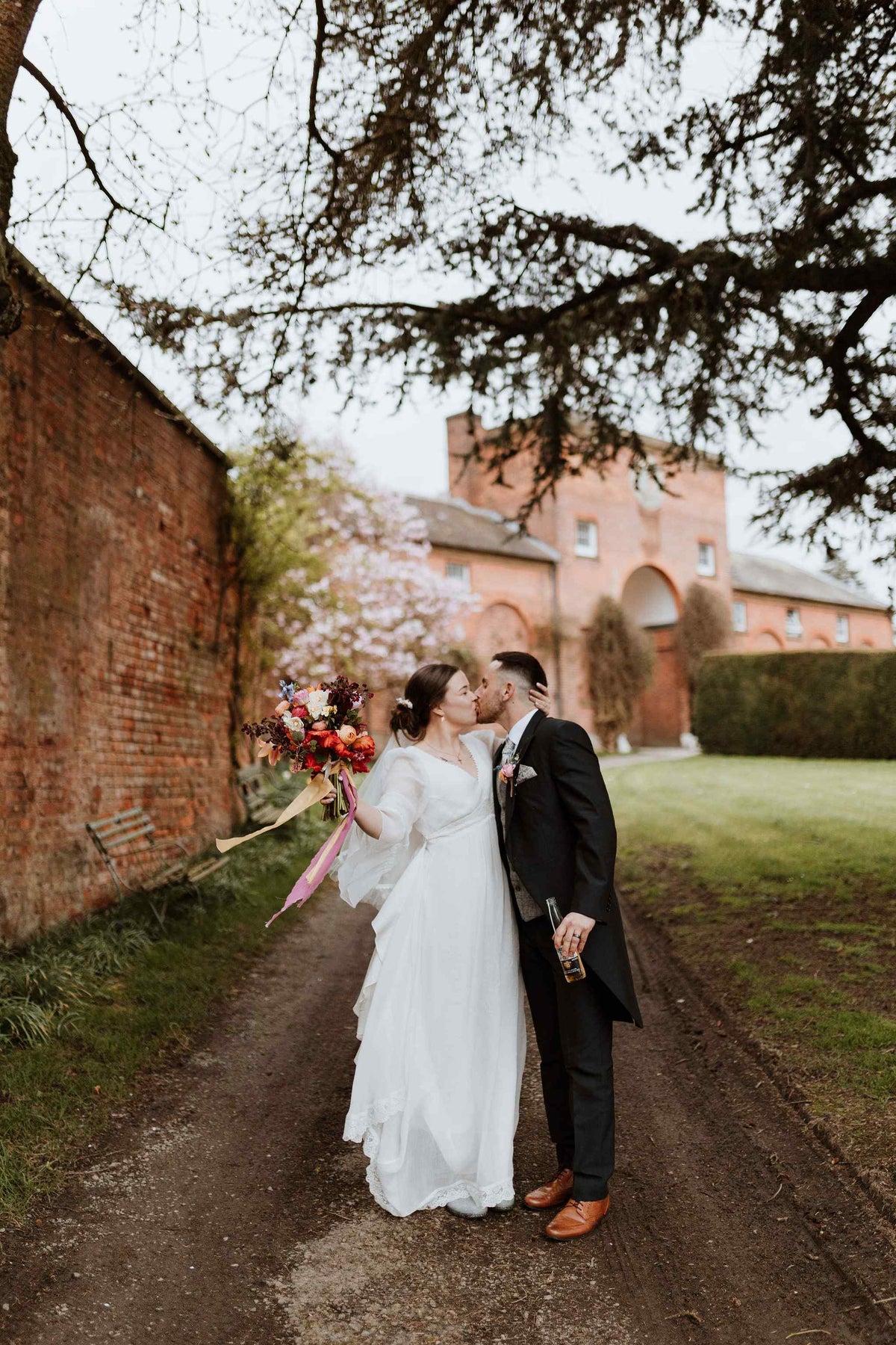 bride and groom kissing under a tree