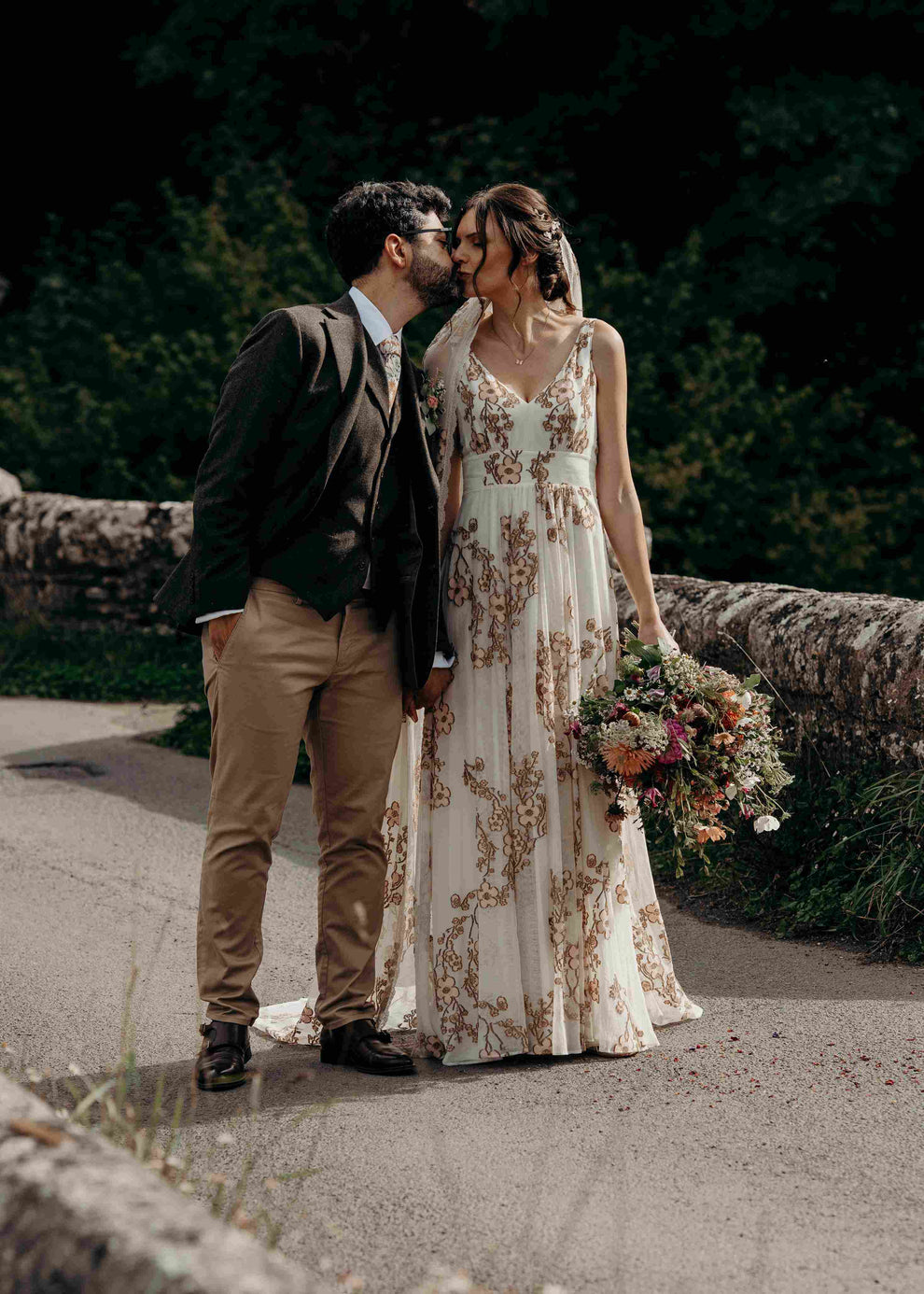 bride wearing a colourful wedding dress kissing the groom