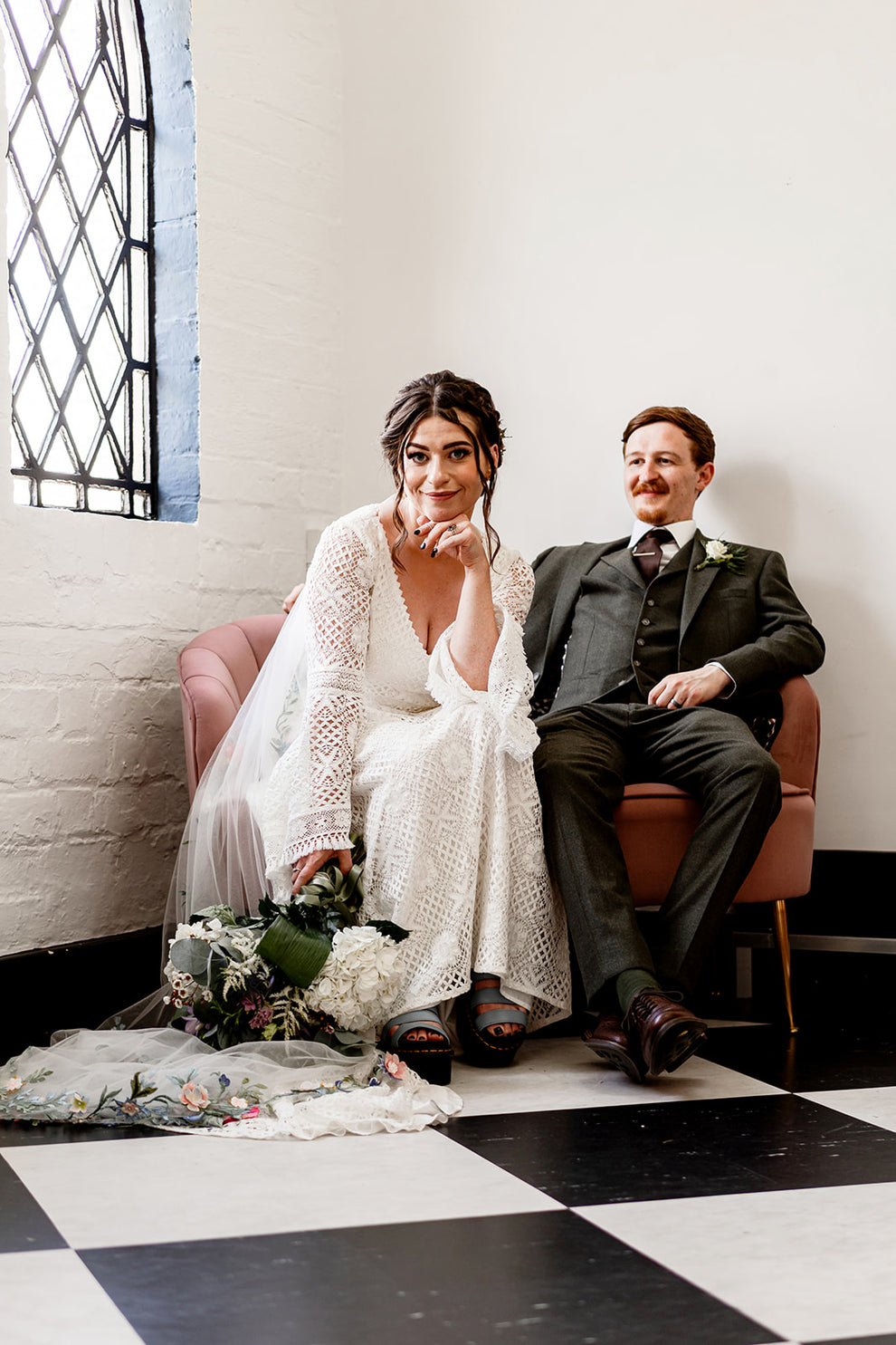cool bride and groom sitting down for a photograph