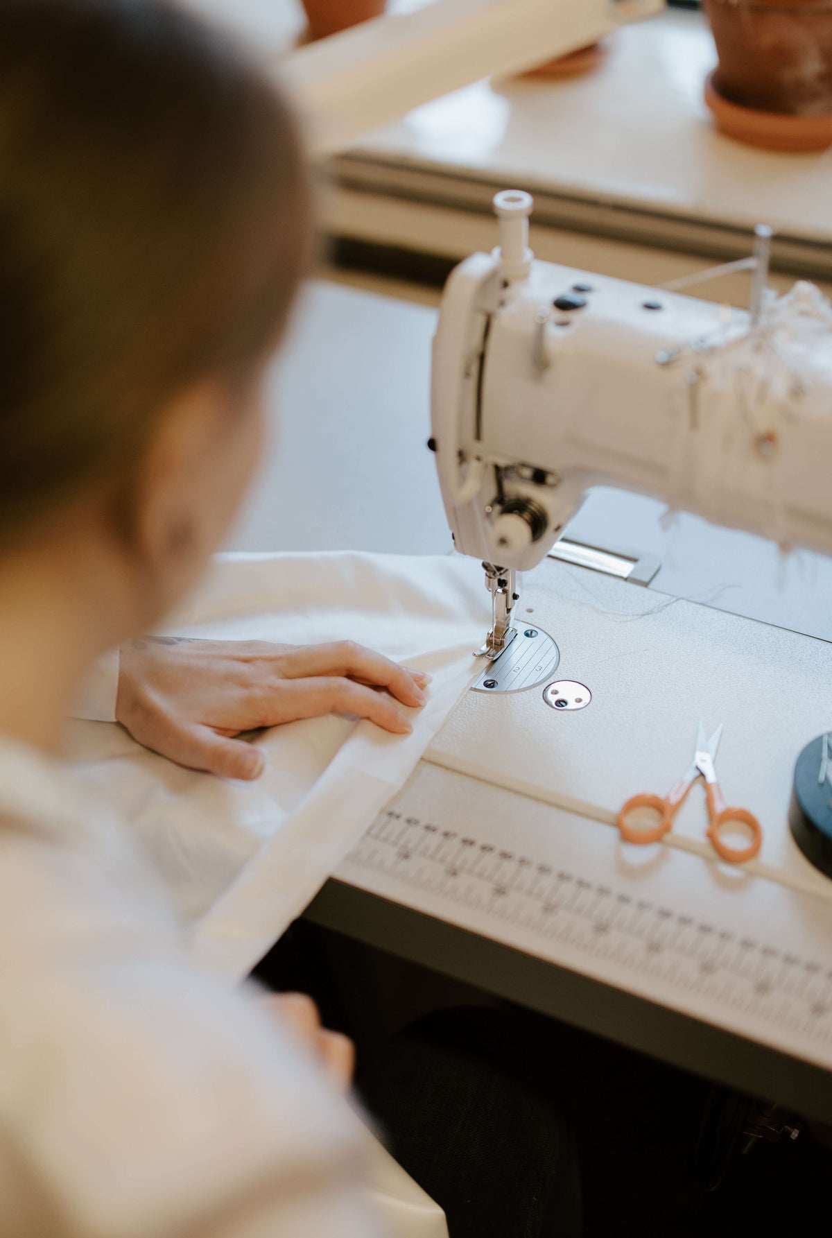 dressmaker sewing a wedding dress