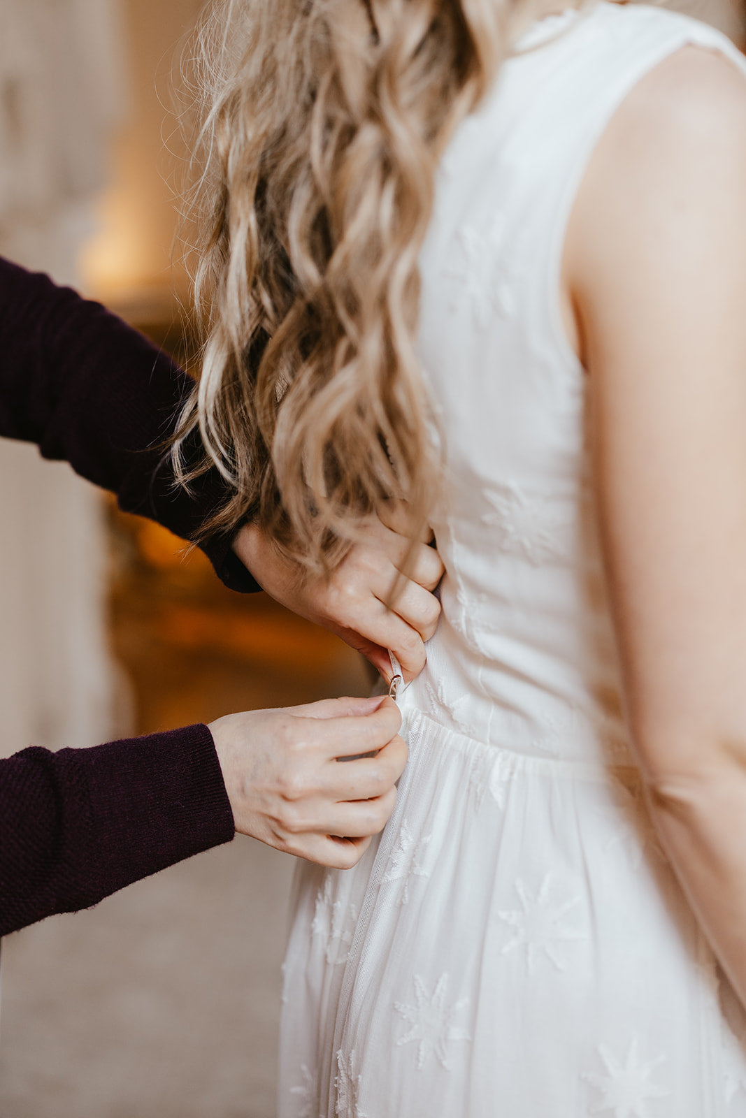 dress maker pinning a wedding dress on a bride during a fitting