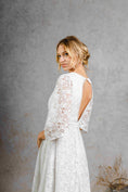 Load image into Gallery viewer, model wearing a modern bohemian lace wedding dress with bell sleeves
