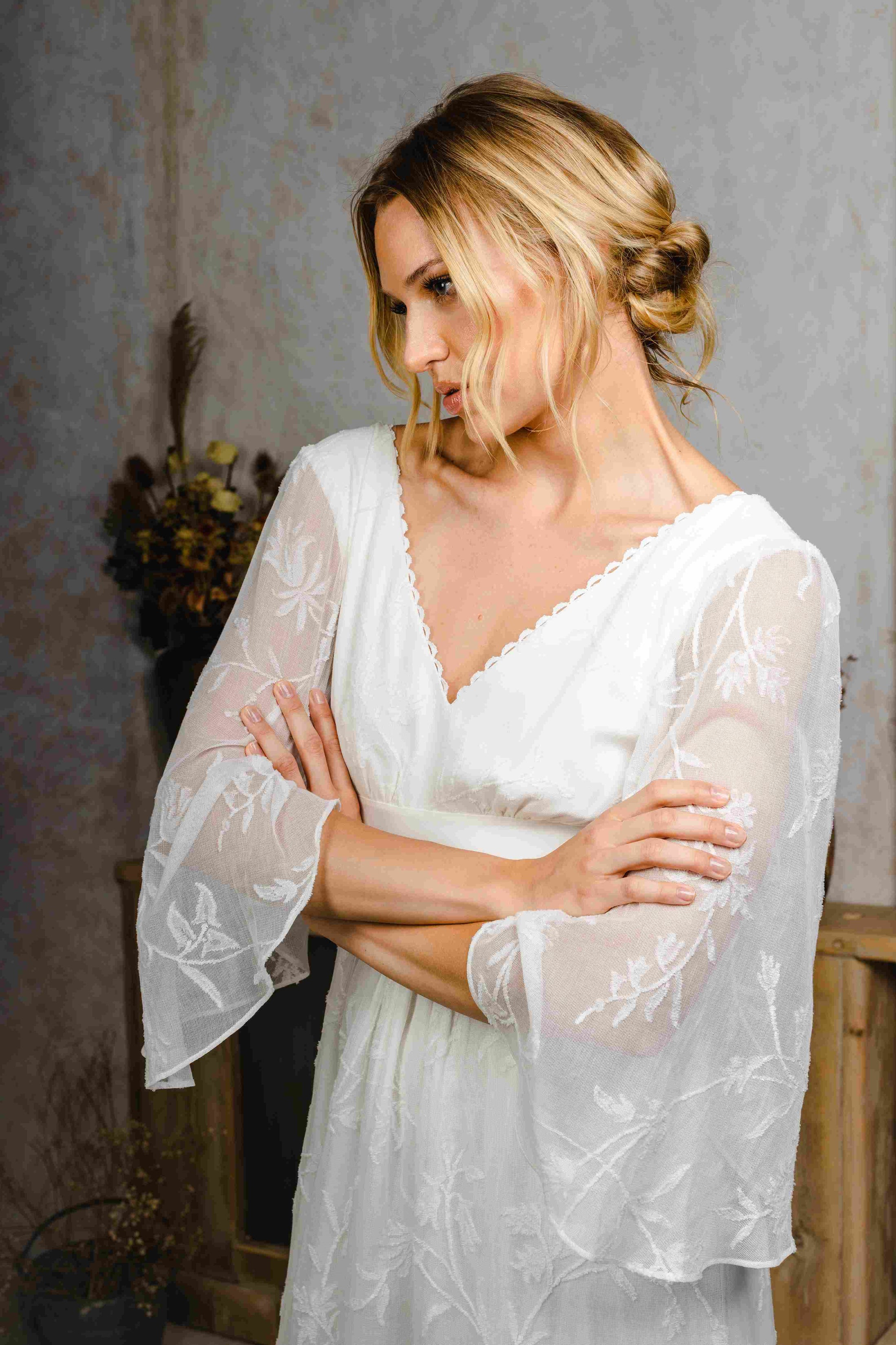 model wearing an outdoors wedding dress with sleeves