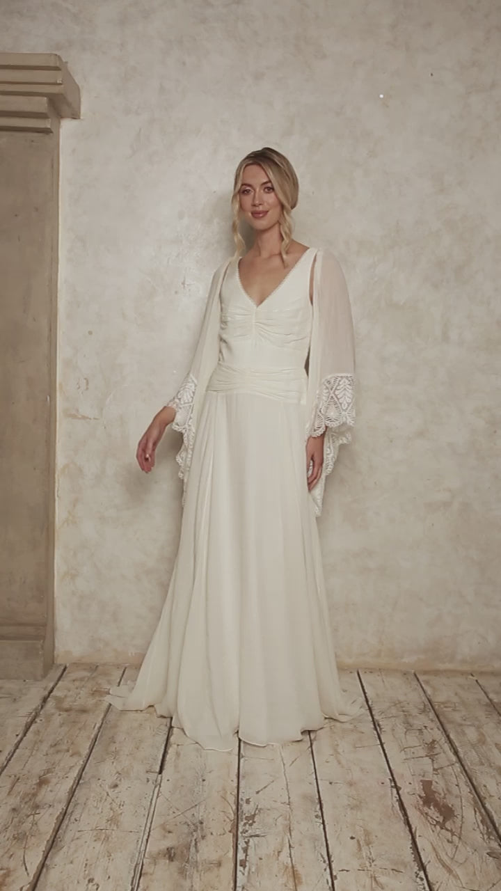 model wearing a modern bohemian wedding dress with angel sleeves