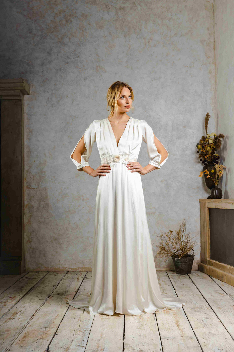 Model wearing a vintage-inspired wedding dress with sleeve slits.